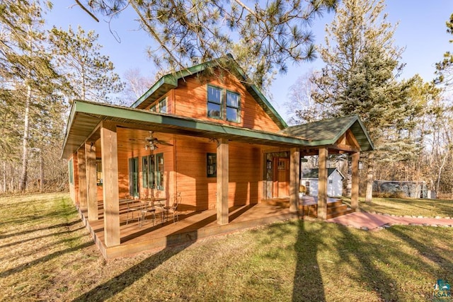 exterior space featuring covered porch, a front yard, and a ceiling fan