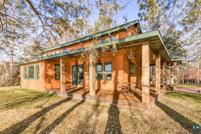 rear view of property featuring a patio, a ceiling fan, and a lawn