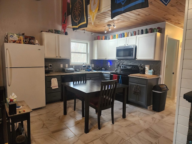 kitchen featuring wood ceiling, black electric range, white cabinets, freestanding refrigerator, and stainless steel microwave