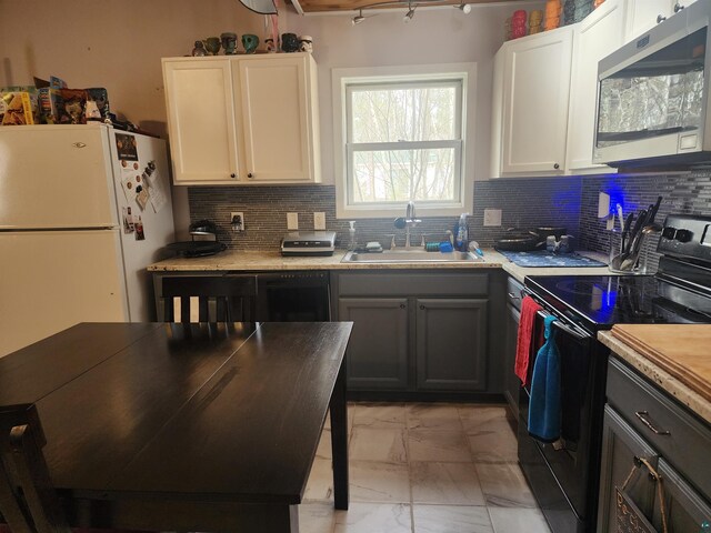 kitchen featuring decorative backsplash, a sink, stainless steel microwave, marble finish floor, and black range with electric cooktop