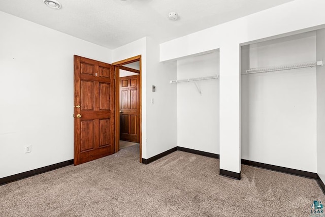 unfurnished bedroom featuring carpet, baseboards, and multiple closets