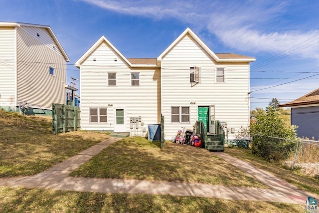 rear view of property with a yard and fence