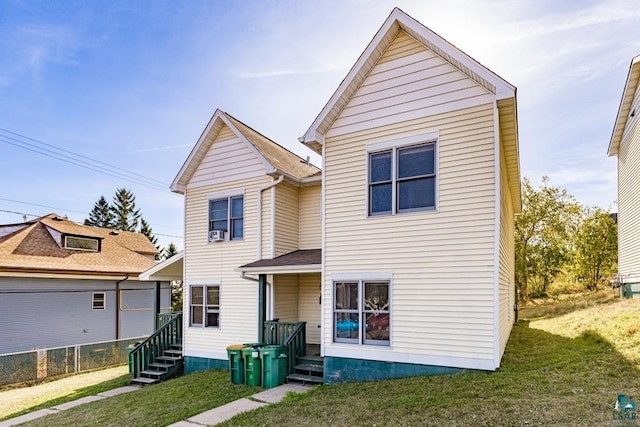 traditional home featuring a front yard, entry steps, and fence