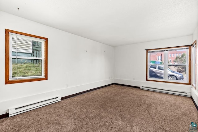 carpeted empty room with baseboard heating and baseboards