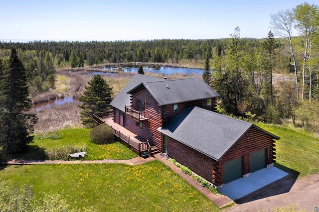 birds eye view of property featuring a forest view and a water view