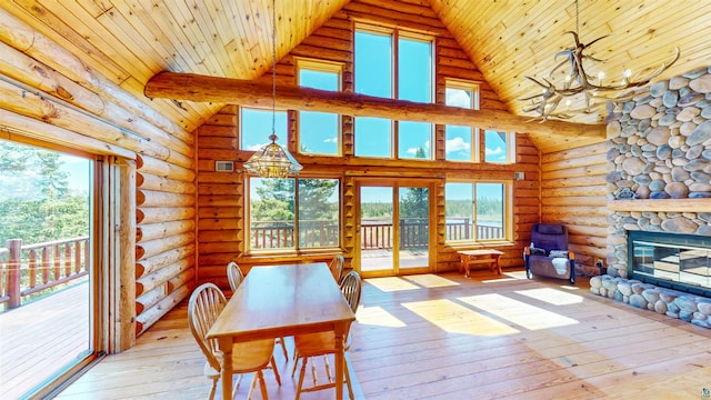 dining area featuring plenty of natural light, light wood-style floors, a chandelier, and high vaulted ceiling