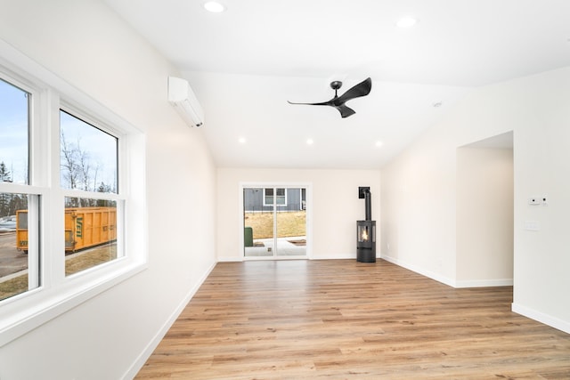 unfurnished room featuring recessed lighting, vaulted ceiling, a wall unit AC, light wood-style flooring, and ceiling fan