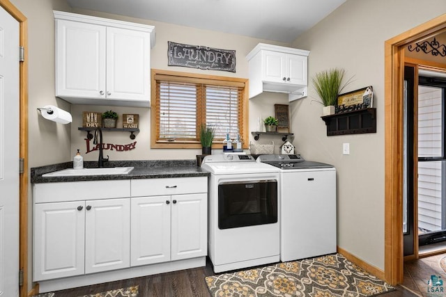 clothes washing area with a sink, washer and dryer, dark wood finished floors, and cabinet space