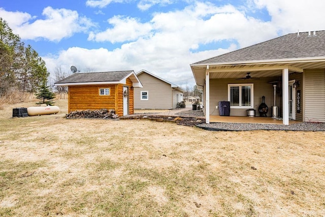 rear view of house featuring a yard, a patio area, a shingled roof, and a ceiling fan