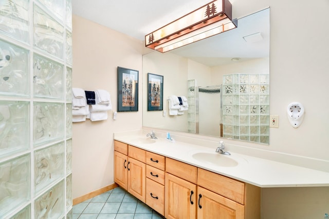 bathroom with tile patterned floors, double vanity, a sink, and a walk in shower