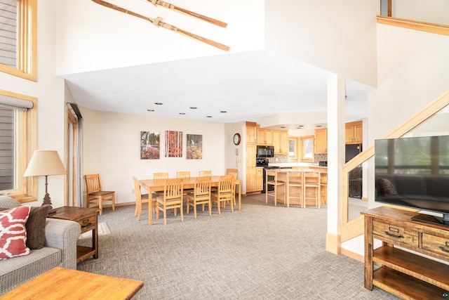 living room with light carpet, a towering ceiling, and recessed lighting