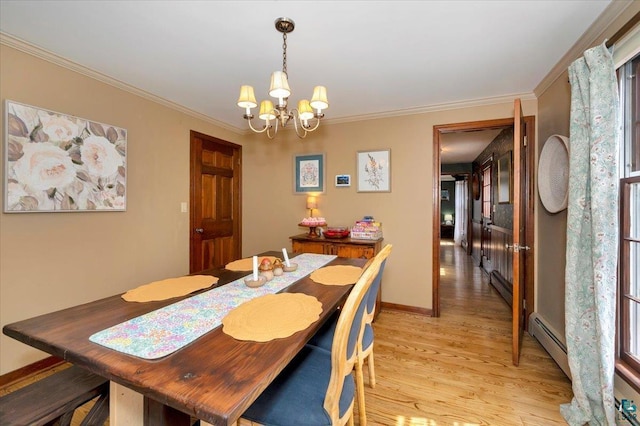 dining area featuring light wood-type flooring, ornamental molding, a notable chandelier, and a baseboard radiator