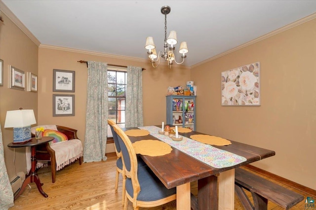 dining room featuring a baseboard heating unit, an inviting chandelier, crown molding, and light wood-type flooring