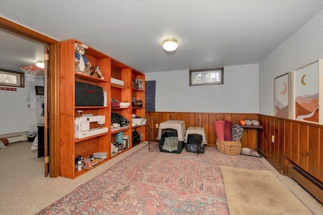 living area with baseboard heating, plenty of natural light, a wainscoted wall, and carpet
