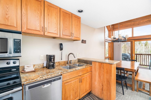 kitchen with a sink, an inviting chandelier, stainless steel appliances, a peninsula, and light stone countertops