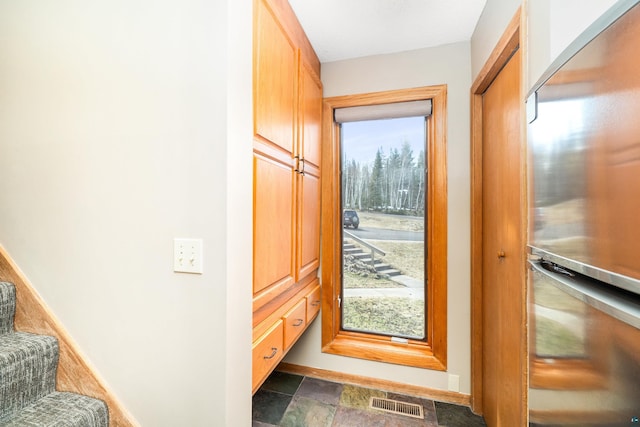 entryway with visible vents, stone finish floor, and stairs