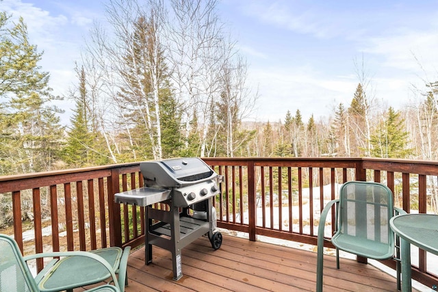 wooden terrace featuring grilling area and outdoor dining space