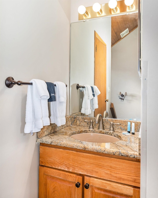 bathroom featuring vaulted ceiling and vanity