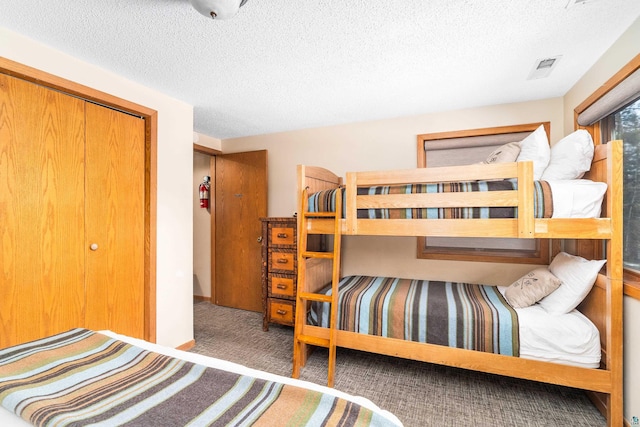carpeted bedroom with a textured ceiling and visible vents
