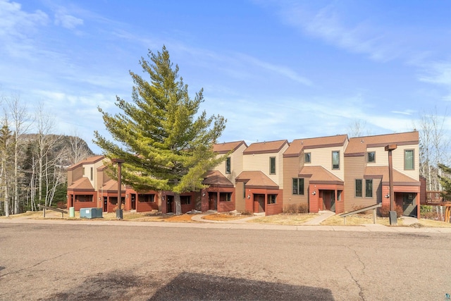 townhome / multi-family property featuring roof with shingles