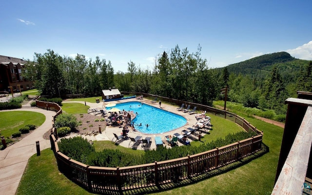 pool featuring fence and a yard