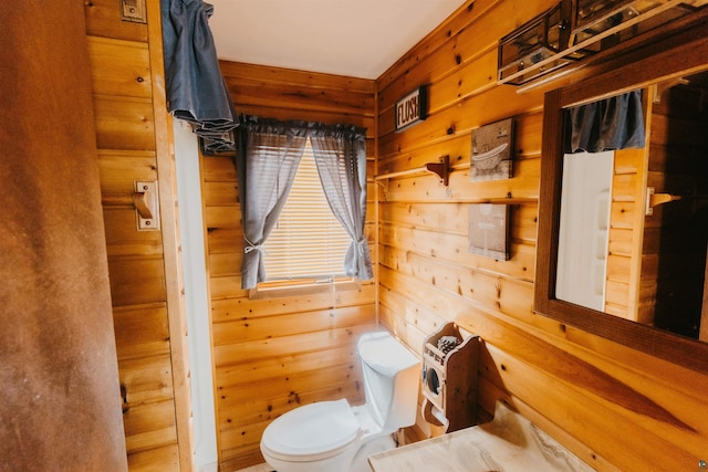 bathroom with toilet and wood walls