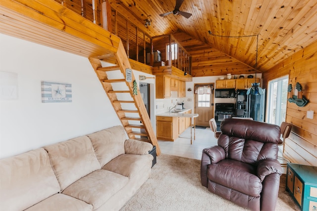living area with lofted ceiling, wood walls, wood ceiling, and ceiling fan