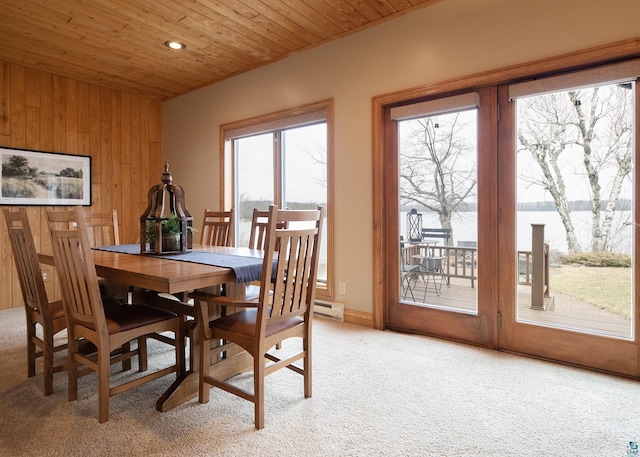 dining space with a baseboard heating unit, wooden walls, light colored carpet, wooden ceiling, and recessed lighting