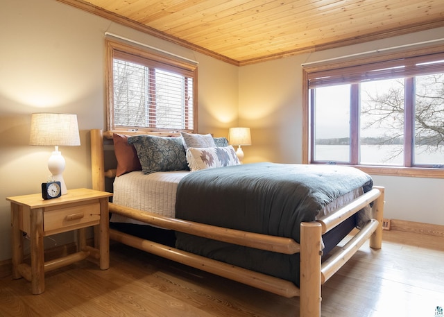 bedroom featuring wood ceiling, wood finished floors, and ornamental molding