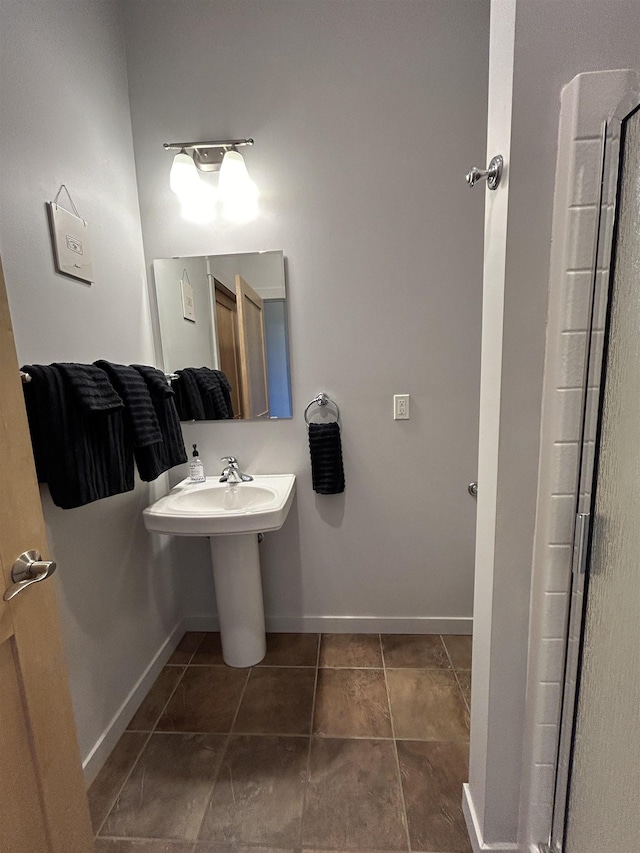 bathroom with baseboards and tile patterned floors