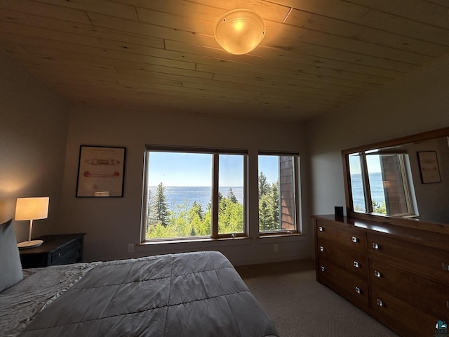 carpeted bedroom featuring wood ceiling, multiple windows, and a water view