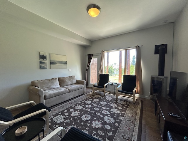 living room featuring dark tile patterned floors and a wood stove