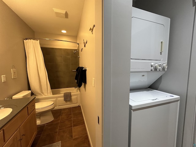 bathroom featuring toilet, visible vents, tile patterned flooring, vanity, and stacked washing maching and dryer