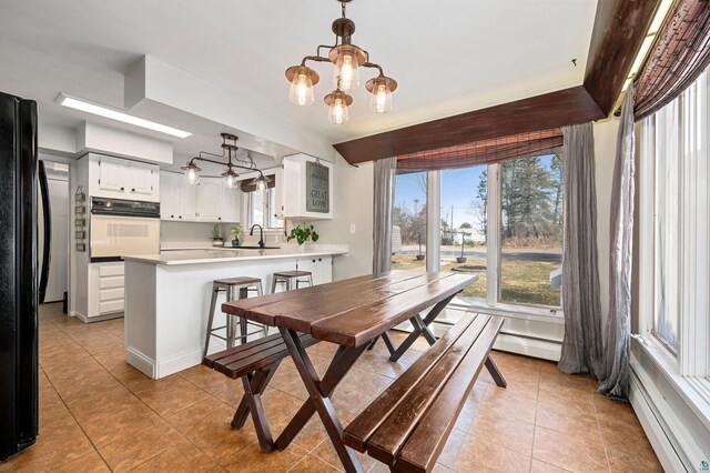 dining room with baseboard heating, an inviting chandelier, and light tile patterned floors