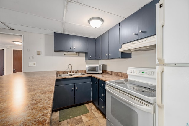 kitchen featuring blue cabinets, a sink, under cabinet range hood, and white appliances