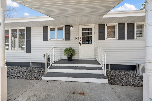 doorway to property featuring a porch and ac unit