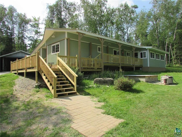 back of house featuring a lawn, a deck, and stairs