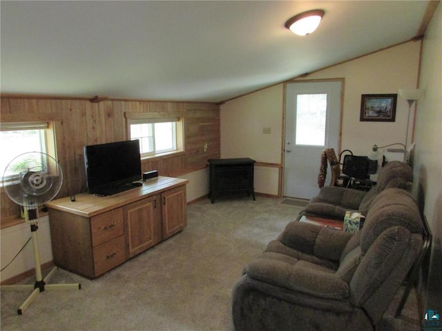 living room with a wealth of natural light, light colored carpet, and vaulted ceiling
