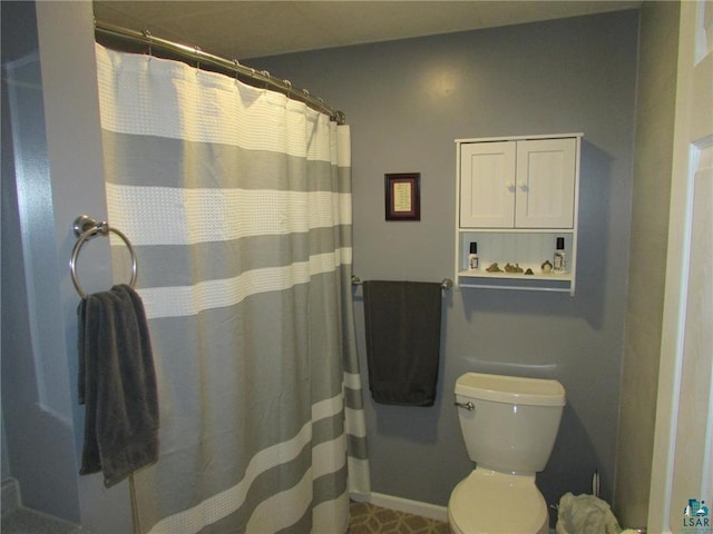 bathroom with baseboards, curtained shower, and toilet