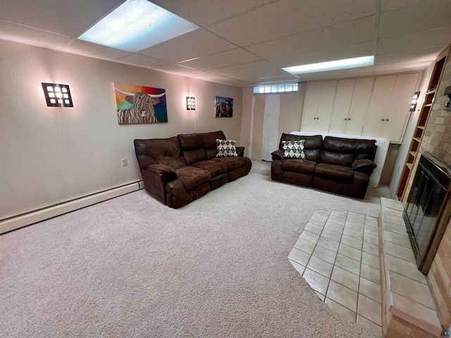 living room with baseboard heating, a brick fireplace, carpet flooring, and a drop ceiling