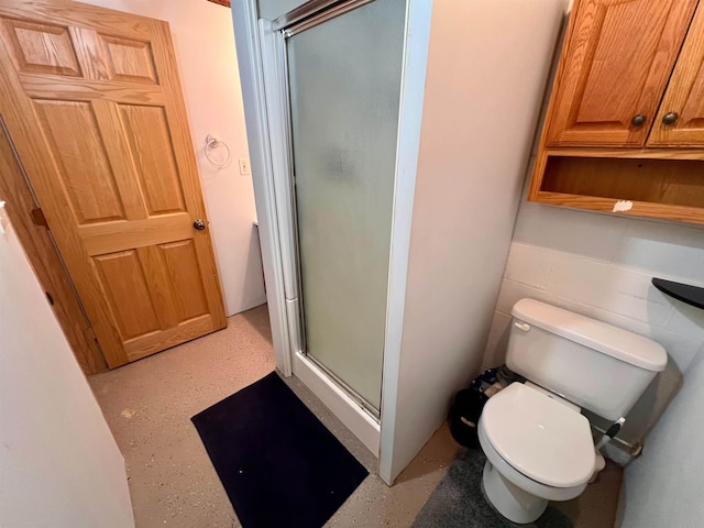 bathroom with toilet and a shower stall