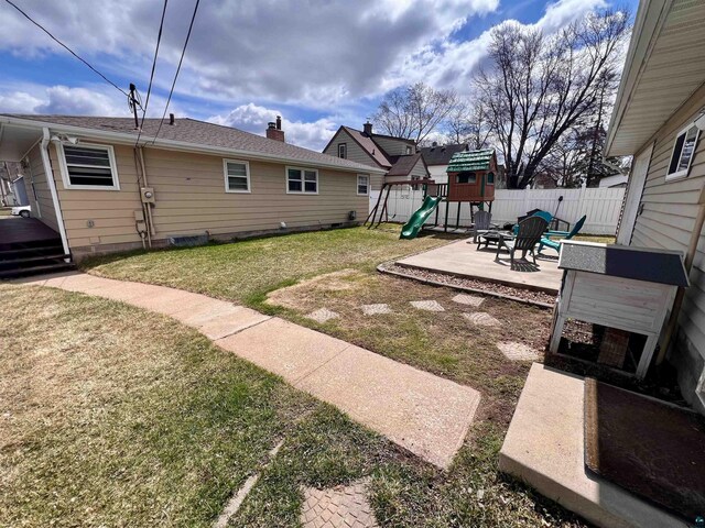 view of yard featuring fence, a patio area, and a playground