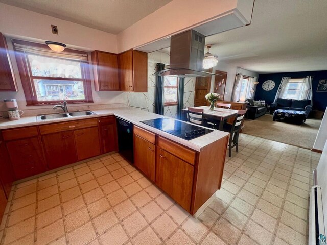 kitchen with a sink, island range hood, light countertops, black appliances, and light floors