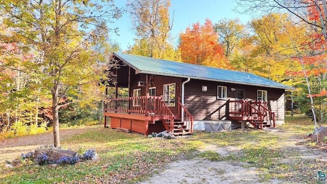 view of front facade with a wooden deck and metal roof