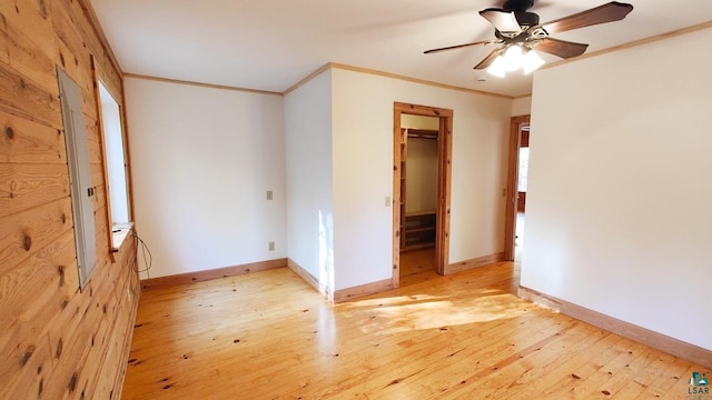 unfurnished bedroom with baseboards, ornamental molding, a ceiling fan, and light wood-style floors