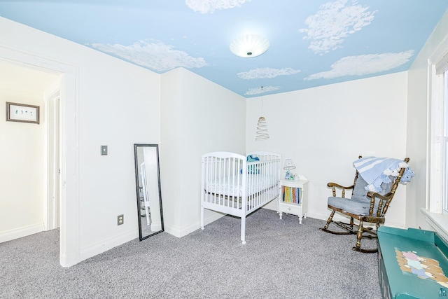 bedroom featuring baseboards, carpet, and a nursery area