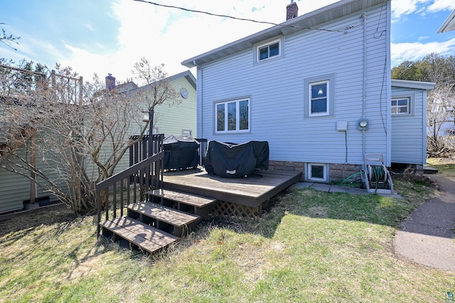 back of property featuring a lawn, a deck, and a chimney