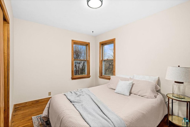 bedroom with baseboards and wood finished floors