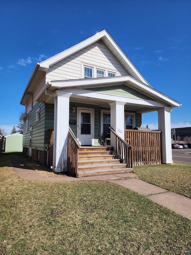 bungalow-style home with a porch and a front lawn