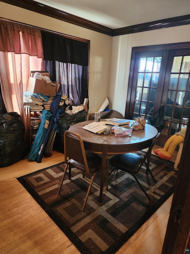dining space featuring crown molding and hardwood / wood-style flooring